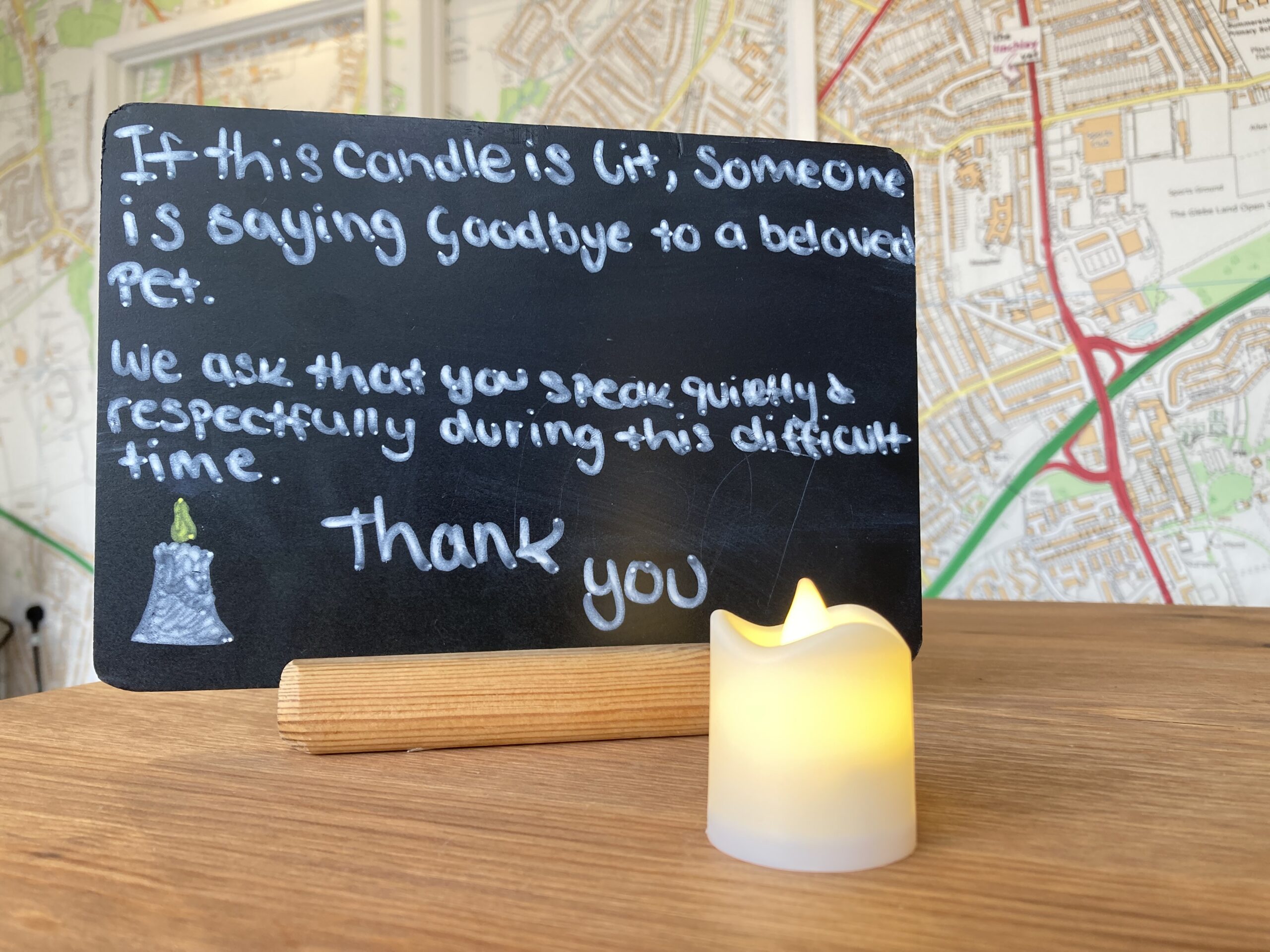 a lit candle with a message on a table